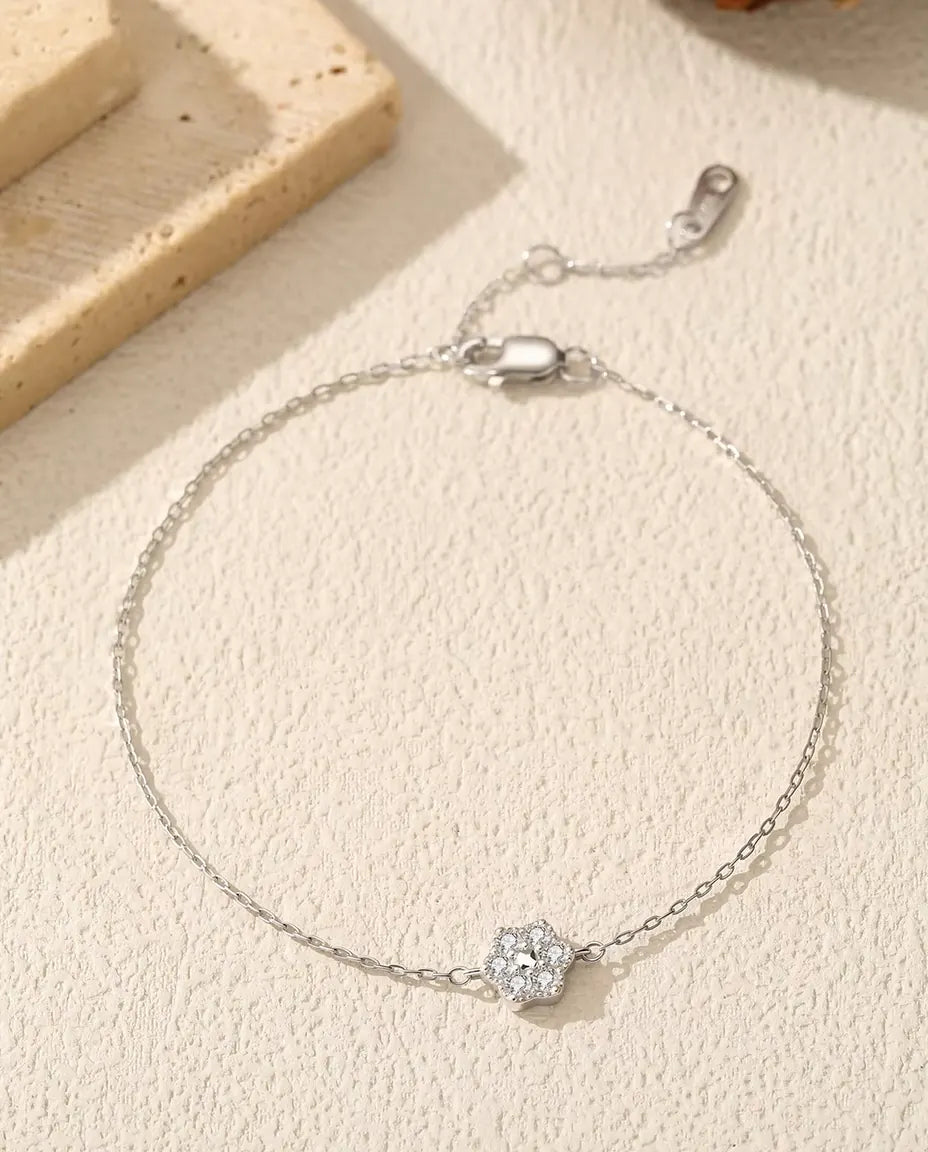 Moissanite Armband med Blomma i 925 Sterlingsilver - liggande på en ljus strukturerad yta med lås och förlängningskedja