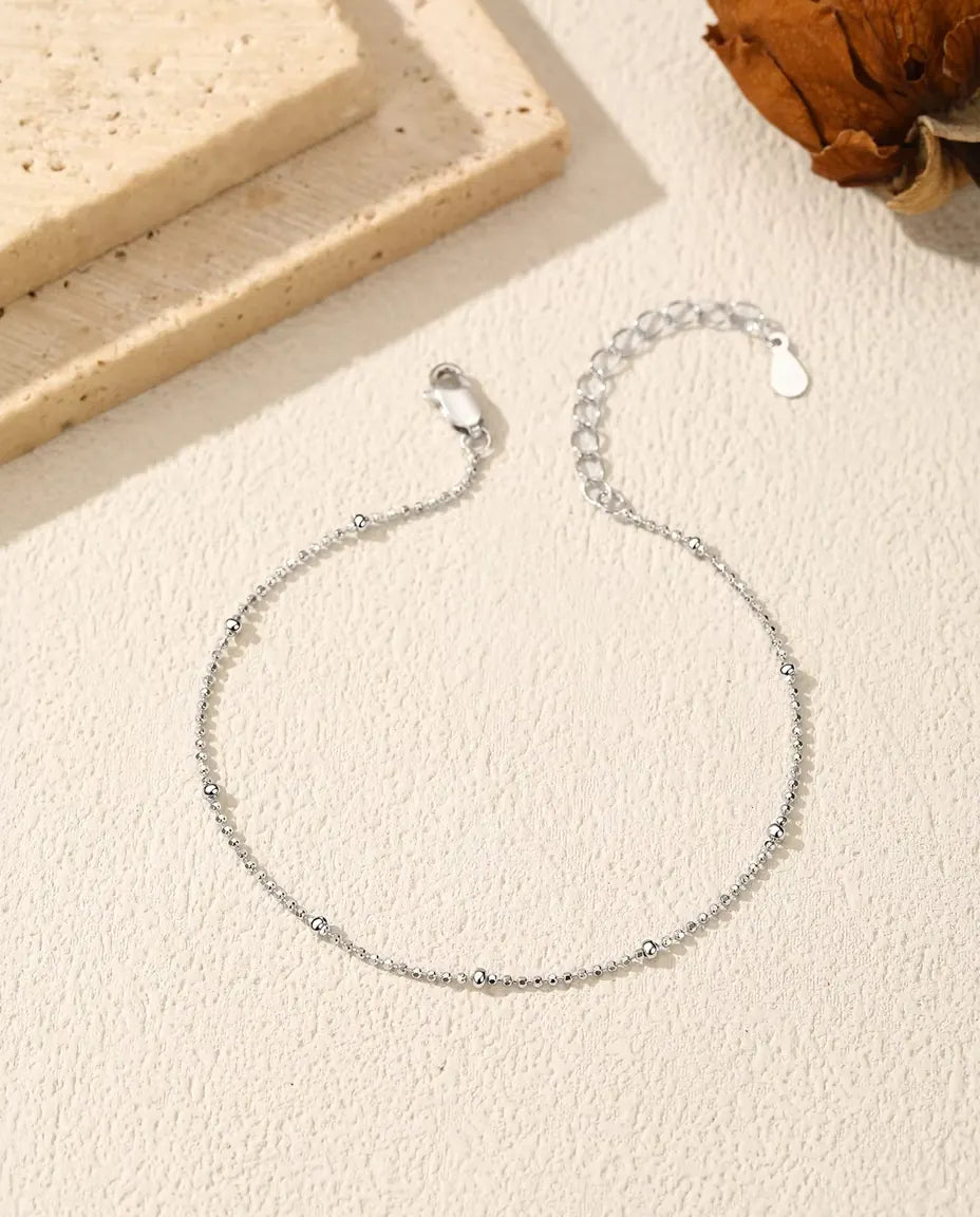 Armband med Kulkedja i 925 Sterlingsilver - liggande på en ljus strukturerad yta med lås och förlängningskedja