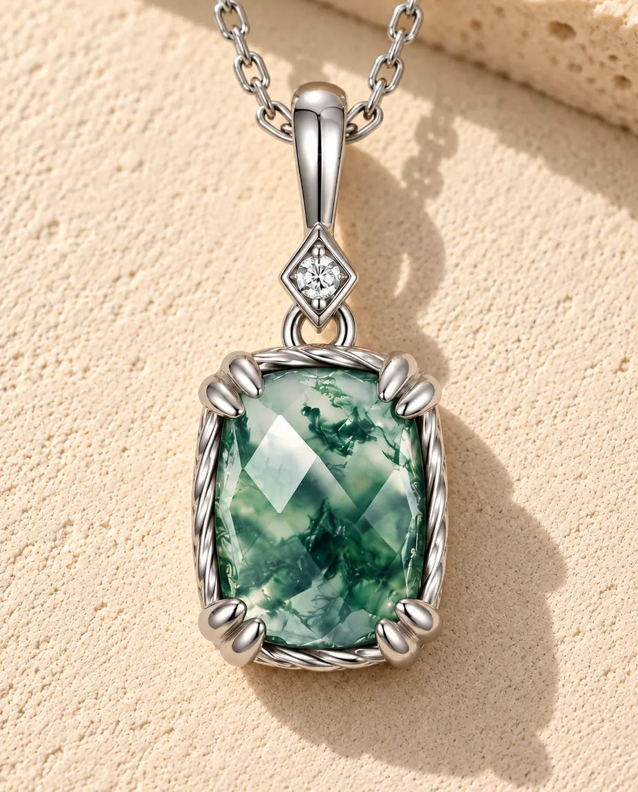 Moss Agate Halsband med Hänge i 925 Sterlingsilver - liggande på en ljus strukturerad yta bredvid ett travertinblock