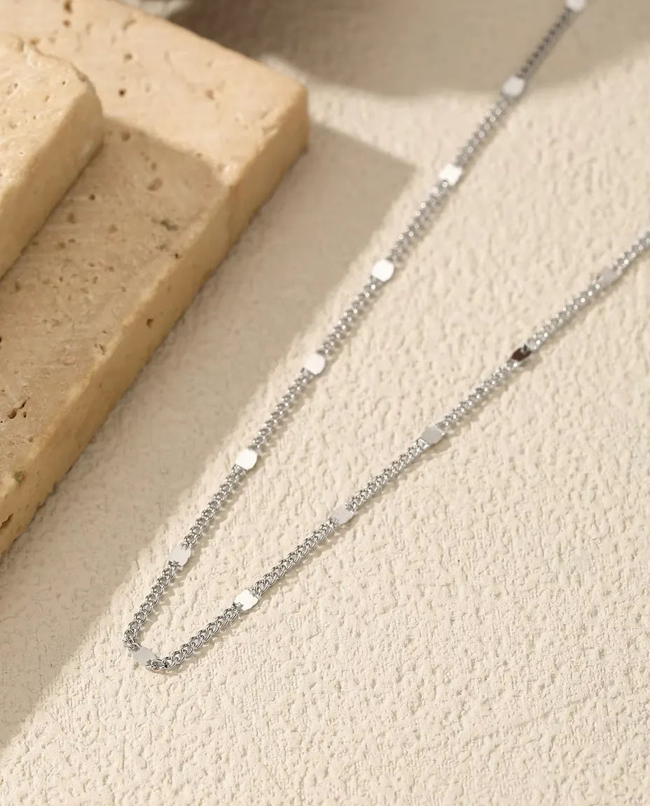 Halsband med Stationskedja i 925 Sterlingsilver - draperat på en ljus yta bredvid en travertinplatta