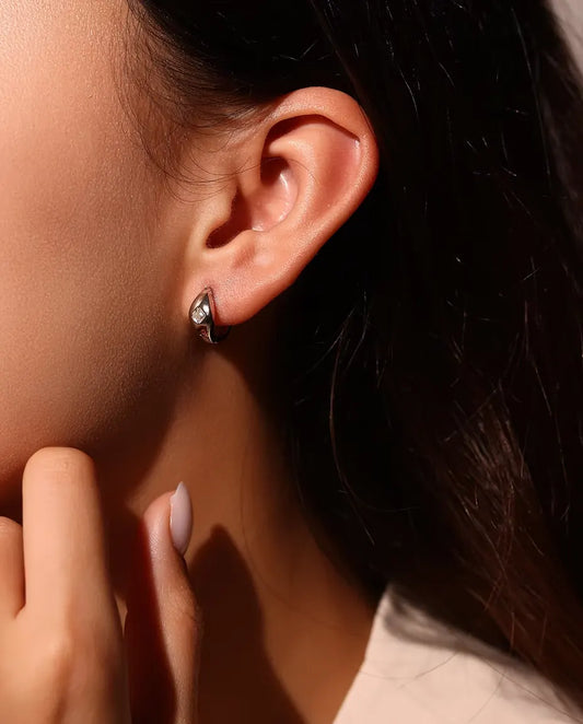 Moissanite Örhängen i 925 Sterlingsilver - burna i en modells öra, handen nära ansiktet