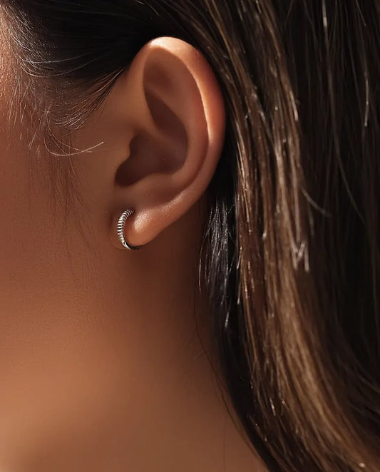 Räfflade Små Creoler i 925 Sterlingsilver - burna i en modells öra, närbild