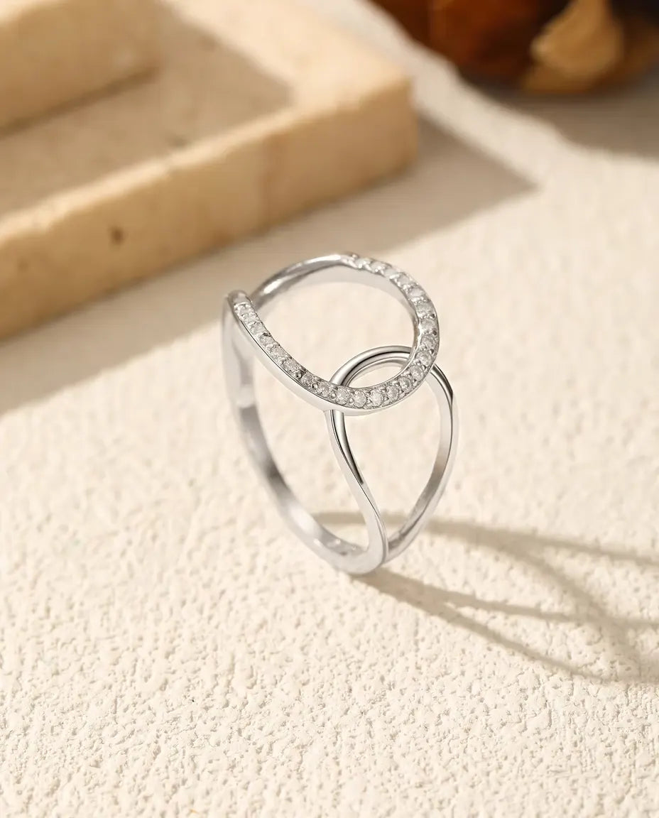 Ring med Sammanflätade Cirklar i 925 Sterlingsilver - stående på en ljus strukturerad yta