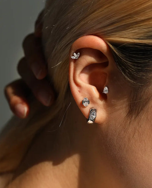 Stiftörhängen med Lotusblomma av Markisslipade Moissaniter i 925 Sterlingsilver - buret av en modell med handen bakom huvudet