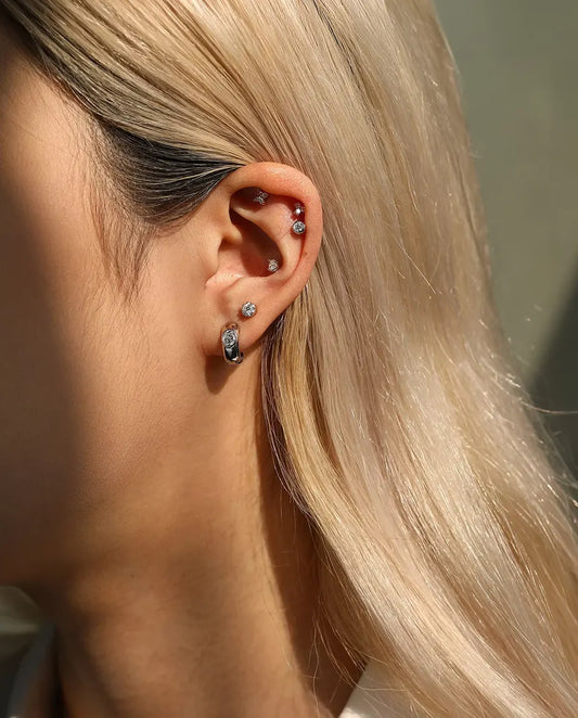 Stiftörhängen med Rund Moissanite och Silverbåge i 925 Sterlingsilver - buret av en modell, bredare bild av öra och hals