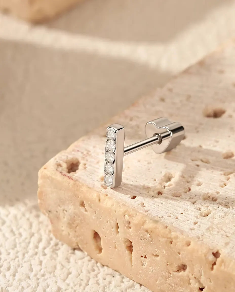 Stiftörhängen med Fem Moissaniter på Rad i 925 Sterlingsilver - på kanten av en travertinplatta