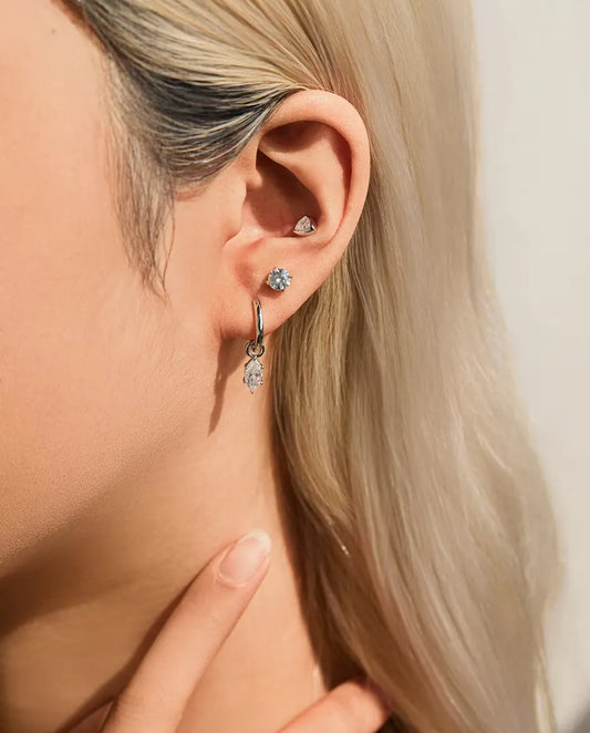 Stiftörhängen med Trekantig Moissanite i Zargfattning i 925 Sterlingsilver - buret i örat, närbild