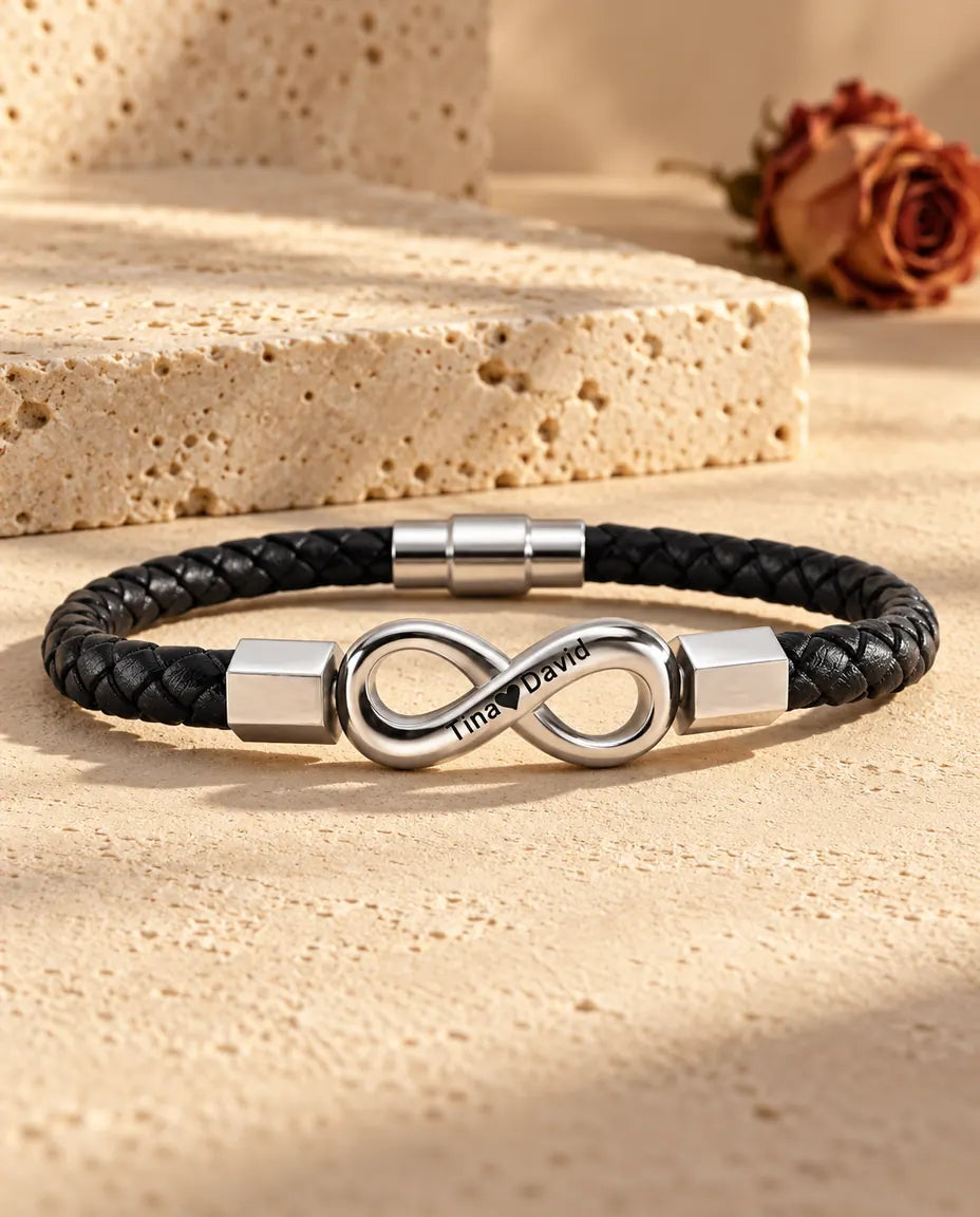 Silverfärgad oändlighetssymbol i rostfritt stål med sexkantiga ändhylsor på ett svart armband i flätat konstläder