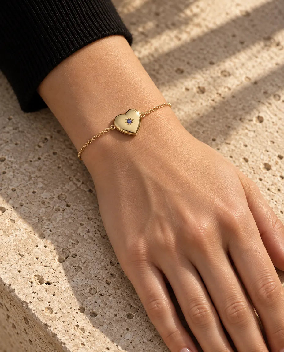 Närbild av armbandet med hjärtmedaljong på handleden