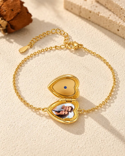 Armband med hjärtmedaljong öppen, en bild i botten och slätt guldfärgat lock