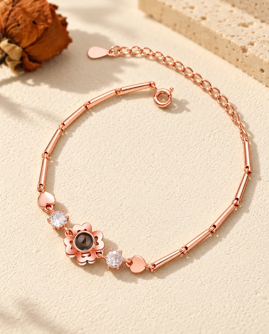Roséguldfärgat armband med klöverblomma, zirkonia och små hjärtlänkar i kedjan