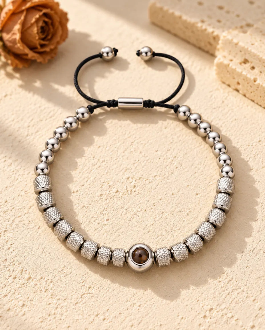 Silverfärgat armband med räfflade pärlor och en rund pärla med projektionssten