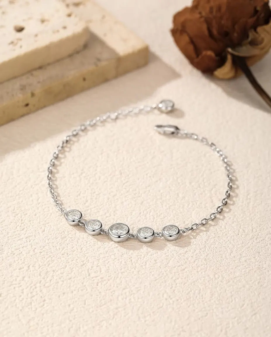Moissanite Armband med Zargfattning i 925 Sterlingsilver - löst lagt på en ljus yta med lås och förlängningskedja