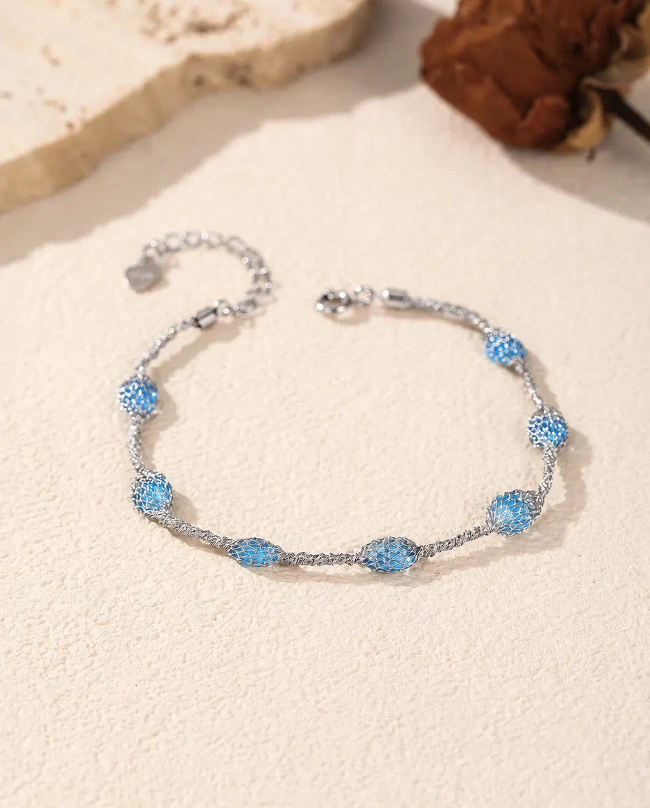 Zirkonia Armband i 925 Sterlingsilver - varianten med blå zirkonia, liggande på en ljus yta