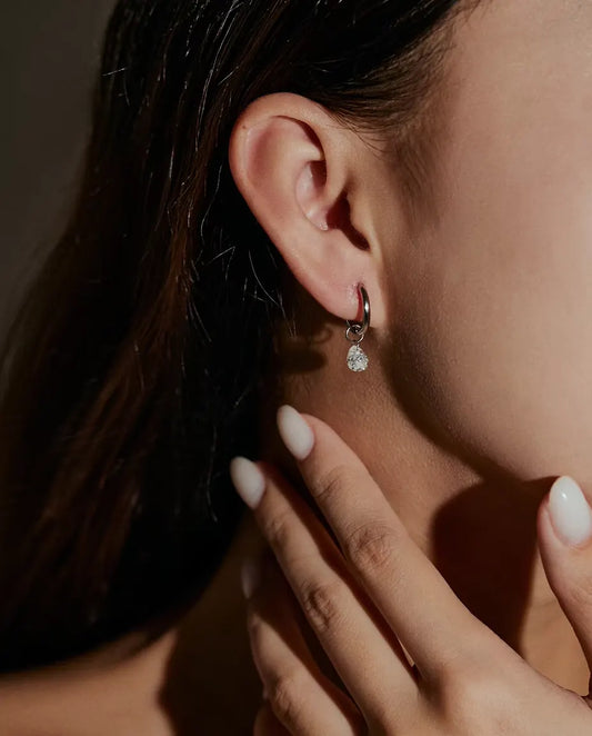 Moissanite Örhängen med Droppe i 925 Sterlingsilver - burna i en modells öra, handen nära ansiktet