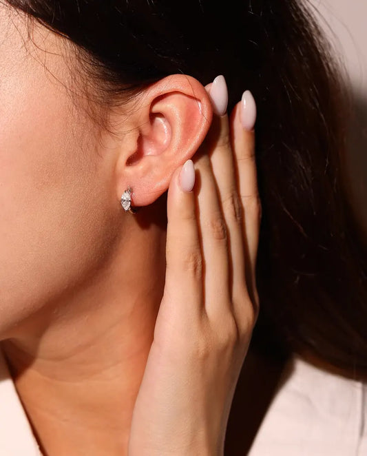 Moissanite Örhängen i 925 Sterlingsilver - burna i en modells öra, handen nära ansiktet