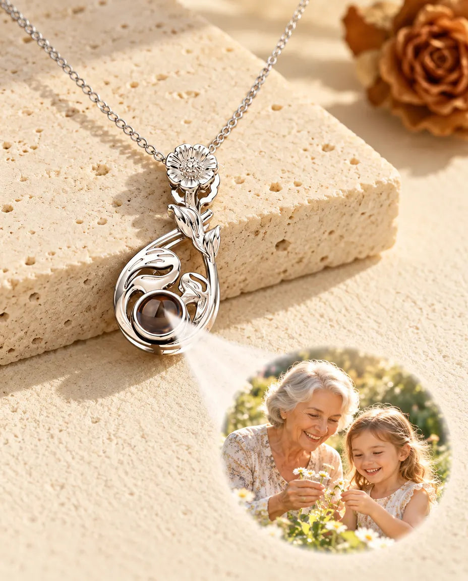 Silverfärgat blomhalsband projicerar en bild på en mormor och hennes barnbarn mot gips