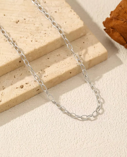 Halsband med Ankarkedja i 925 Sterlingsilver - kedjan draperad över en travertinplatta, närbild