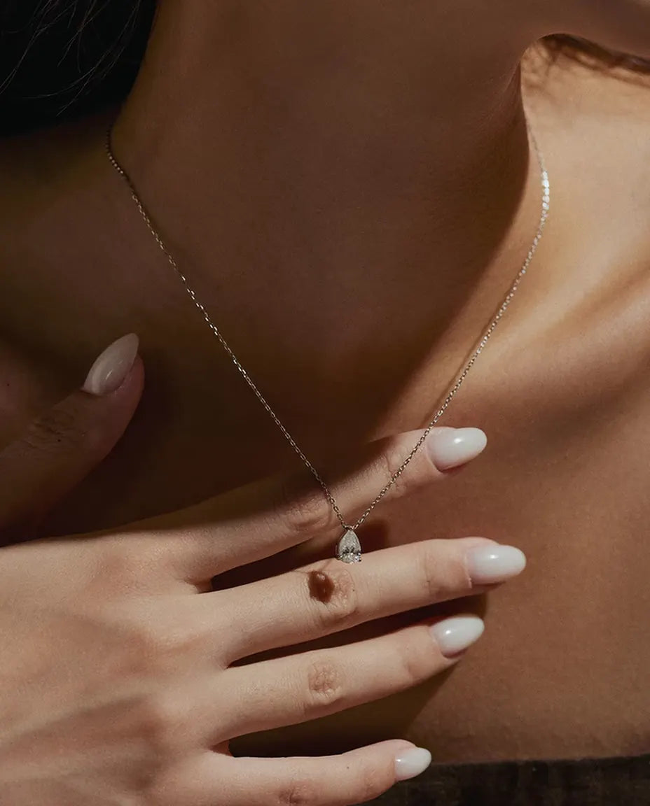 Moissanite Halsband 1 ct i 925 Sterlingsilver - buret av en modell med handen vid halsen