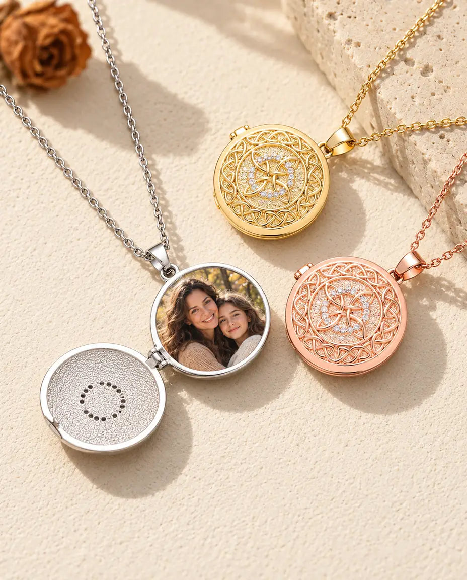 Öppnad silverfärgad medaljong med en bild på mamma och tonårsdotter, bredvid en stängd guldfärgad och en roséguldfärgad