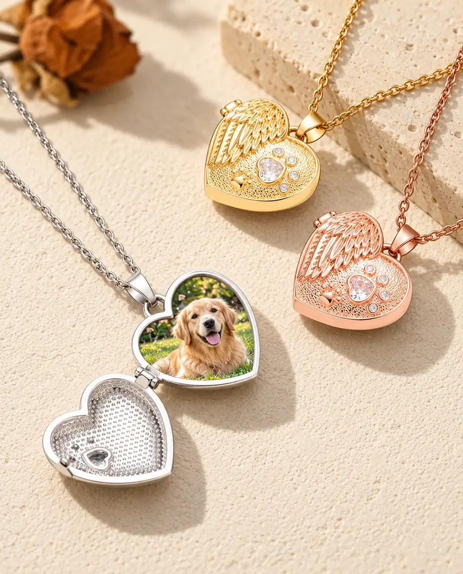 Öppnad silverfärgad hjärtmedaljong med en bild på en golden retriever, bredvid en stängd guldfärgad och en roséguldfärgad