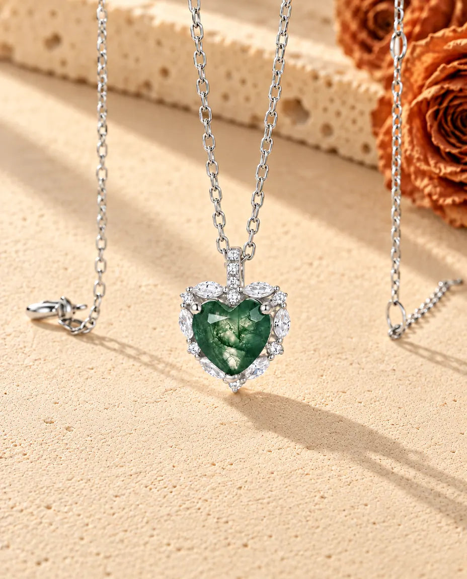 Moss Agate Halsband med Hjärta i 925 Sterlingsilver - fotograferat snett på en ljus strukturerad yta