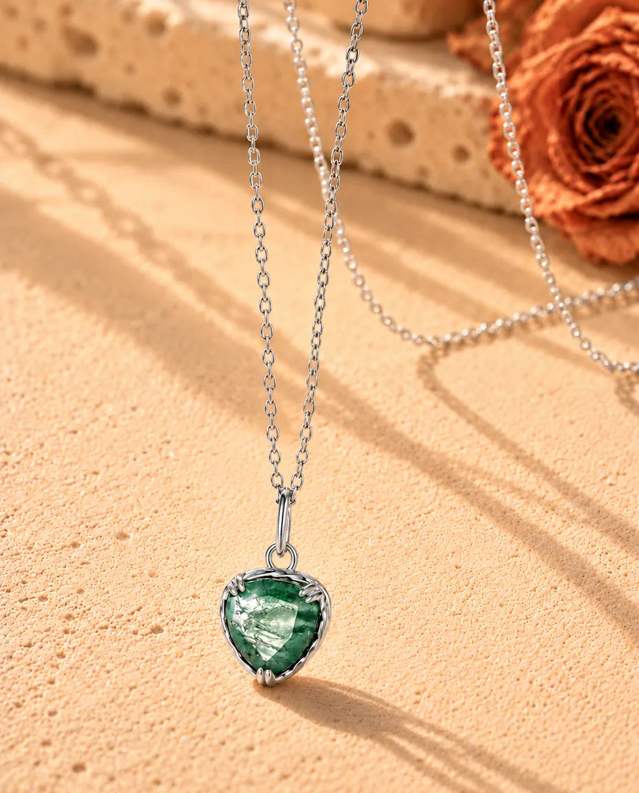 Moss Agate Halsband med Hjärta i 925 Sterlingsilver - fotograferat snett på en ljus strukturerad yta