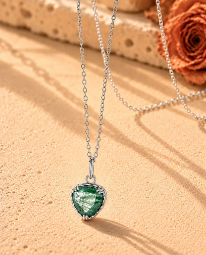 Moss Agate Halsband med Hjärta i 925 Sterlingsilver - fotograferat snett på en ljus strukturerad yta