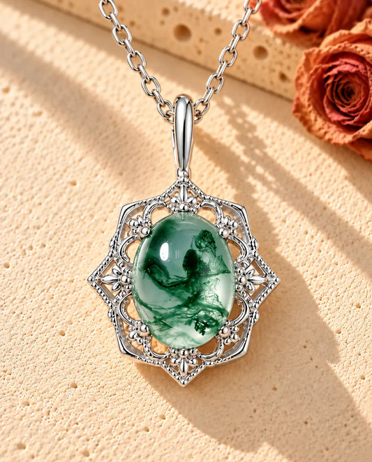 Moss Agate Halsband i Vintagestil i 925 Sterlingsilver - liggande på en ljus strukturerad yta bredvid ett travertinblock