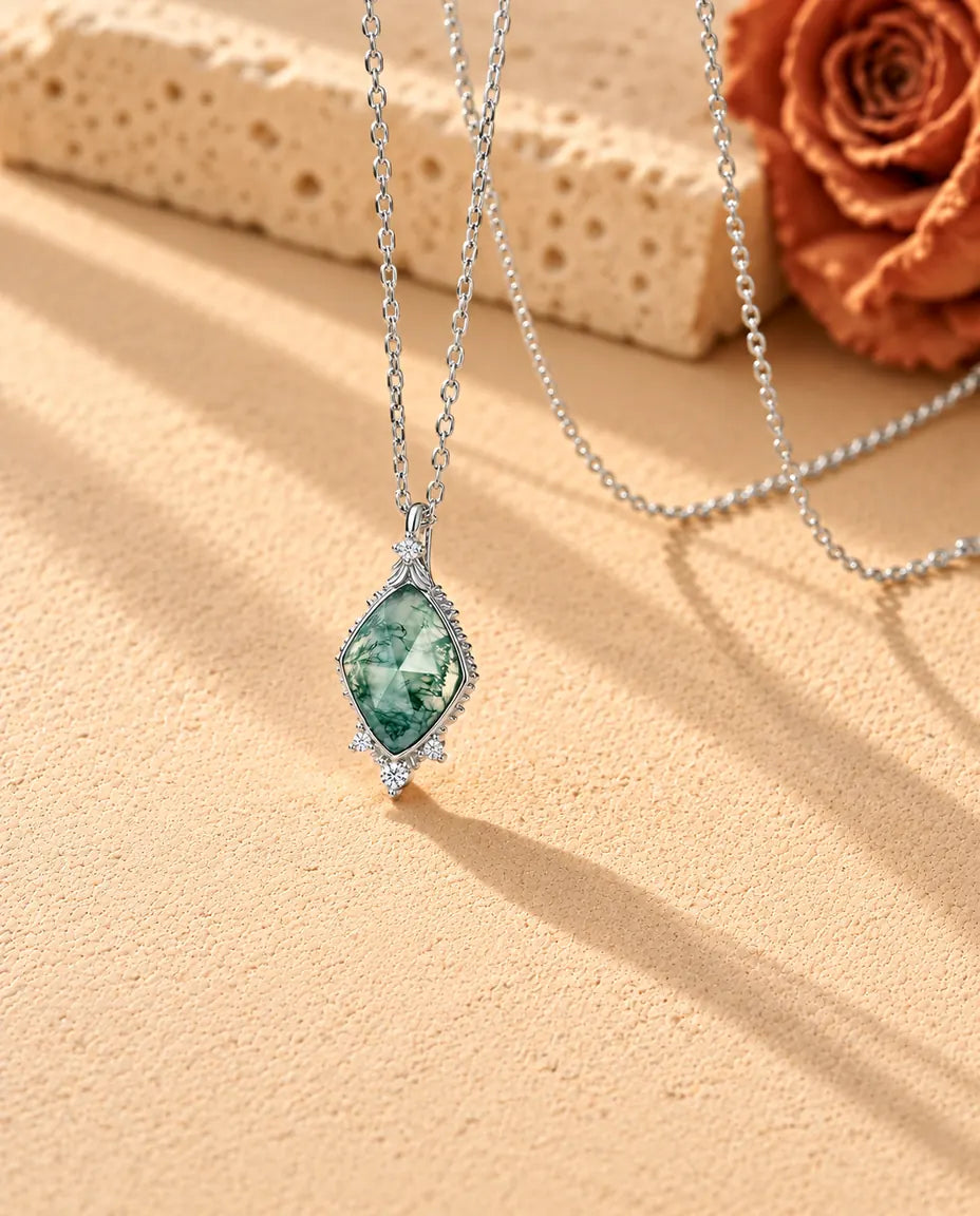 Moss Agate Halsband med Romb i 925 Sterlingsilver - fotograferat snett på en ljus strukturerad yta