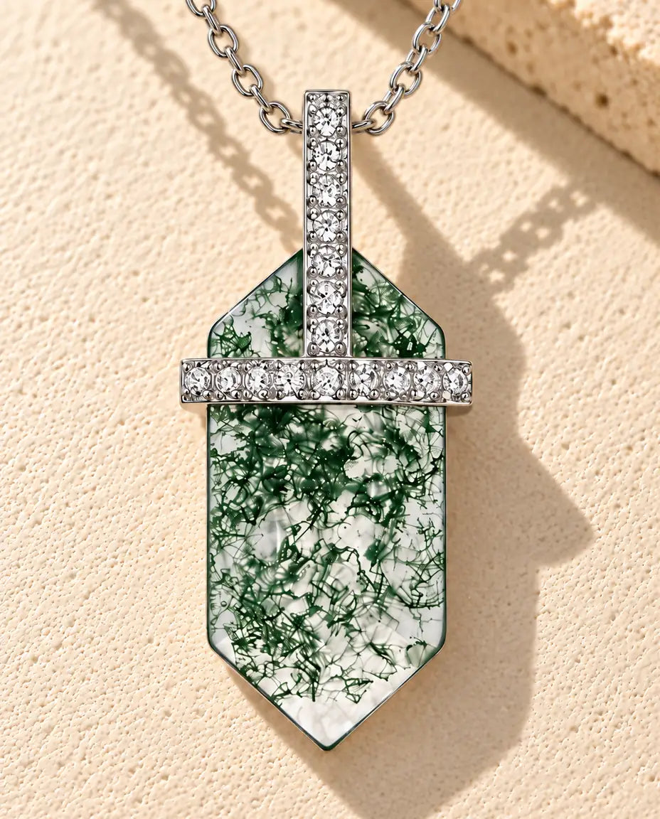 Moss Agate Halsband med Sexkantig Platta i 925 Sterlingsilver - liggande på en ljus strukturerad yta bredvid ett travertinblock