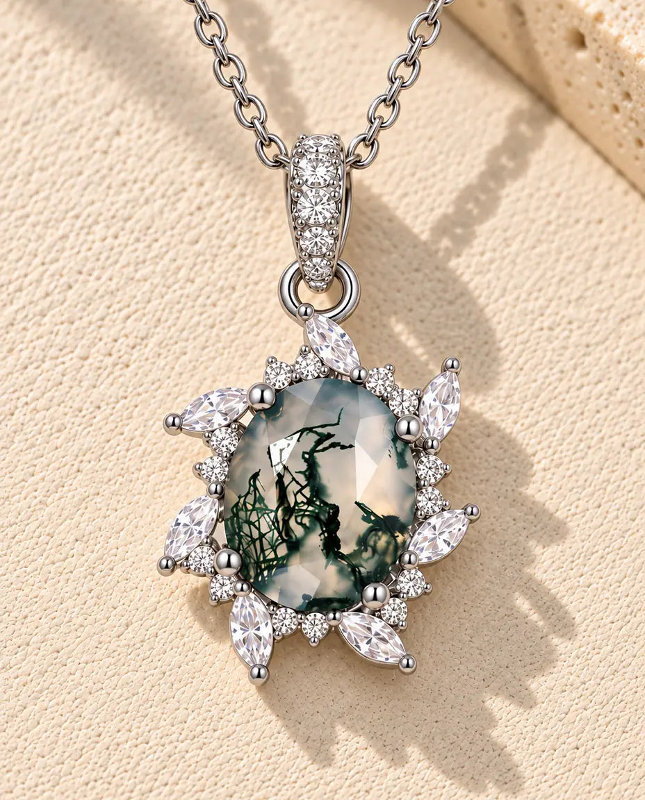 Moss Agate Halsband Sol i 925 Sterlingsilver - liggande på en ljus strukturerad yta bredvid ett travertinblock