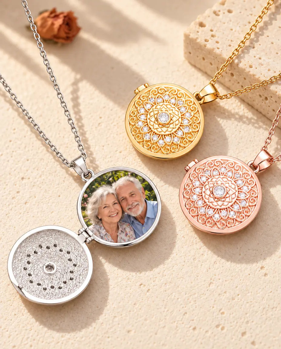 Öppnad silverfärgad medaljong med en bild på far- och morföräldrar, bredvid en stängd guldfärgad och en roséguldfärgad