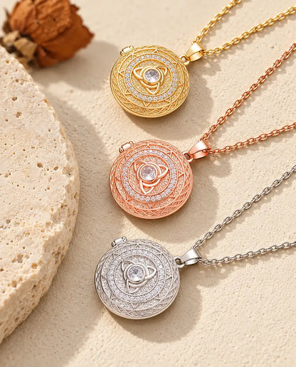 Guldfärgade, roséguldfärgade och silverfärgade triquetra-medaljonger staplade intill en travertinplatta