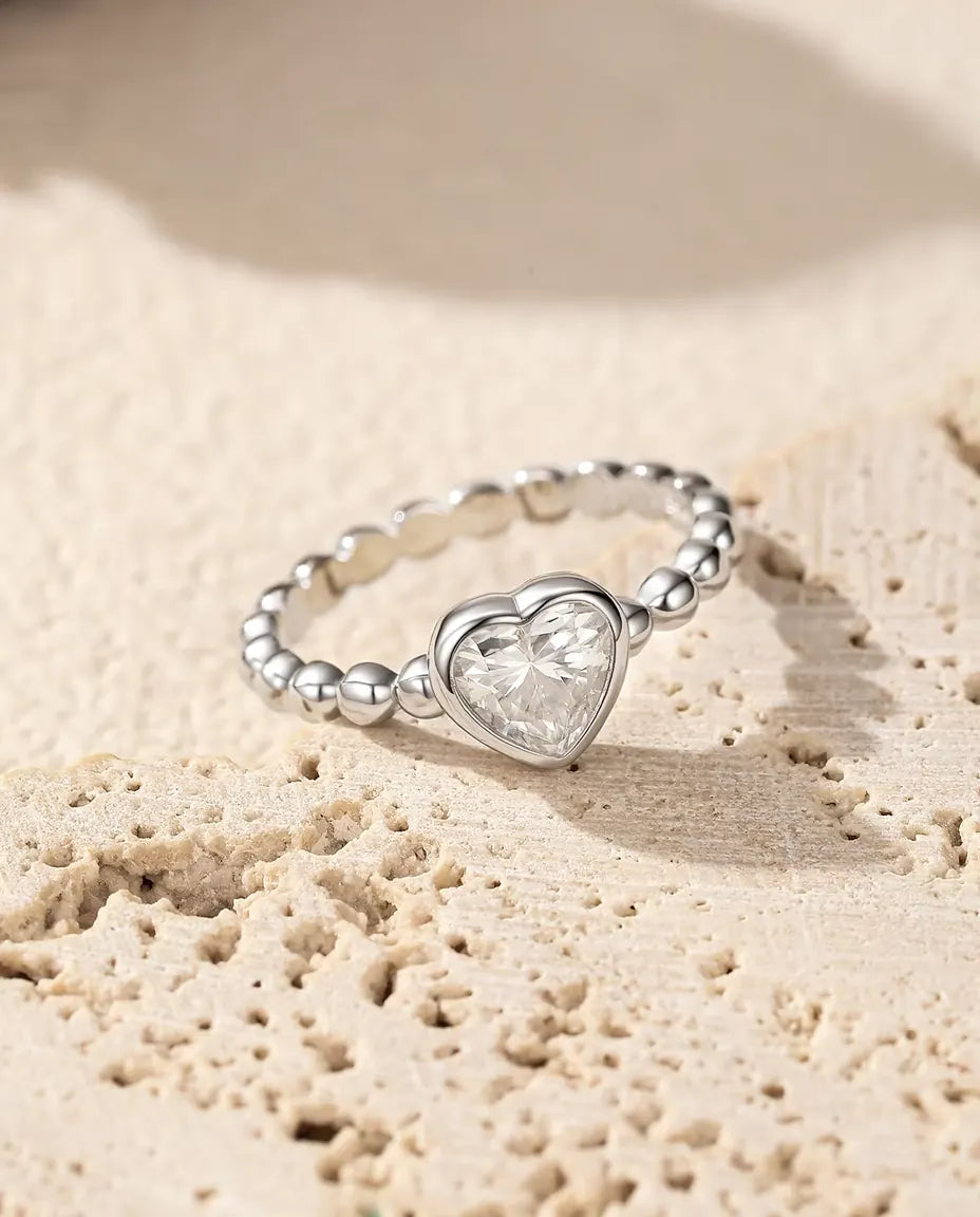 Moissanite Ring med Hjärta i 925 Sterlingsilver - på en porös travertinyta