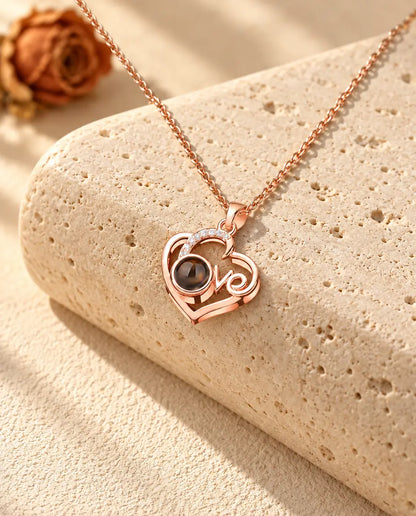 Roséguldfärgat halsband med Love-hjärta och bild inuti på travertin i varmt solljus