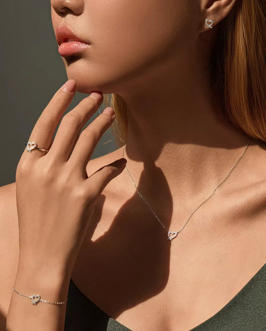 Modell som bär hela moissanite-hjärtsetet: halsband, armband, ring och örhängen