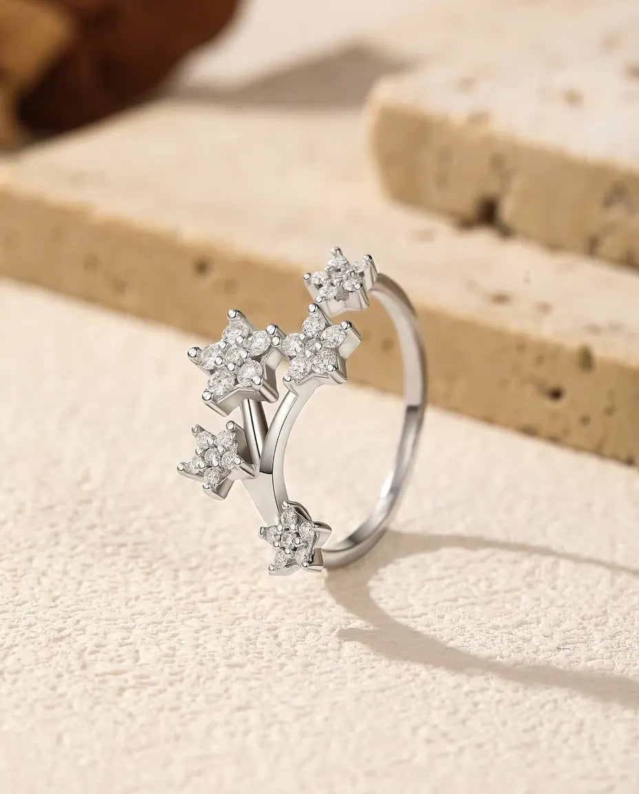 Öppen Moissanite Ring med Stjärnor i 925 Sterlingsilver - stående på en ljus strukturerad yta