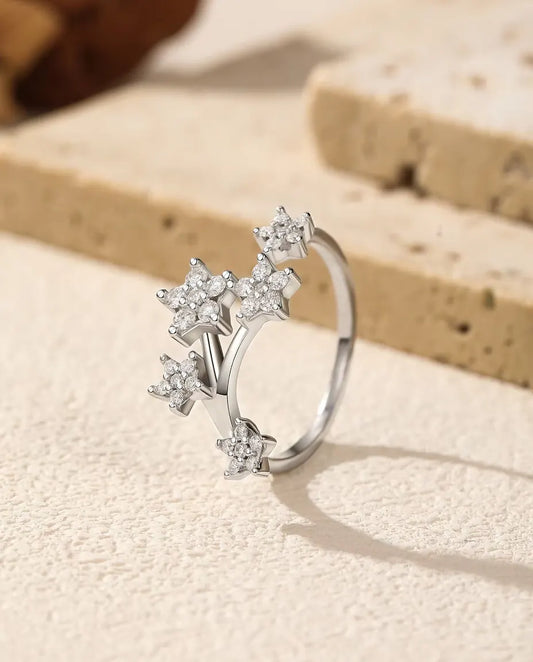 Öppen Moissanite Ring med Stjärnor i 925 Sterlingsilver - stående på en ljus strukturerad yta