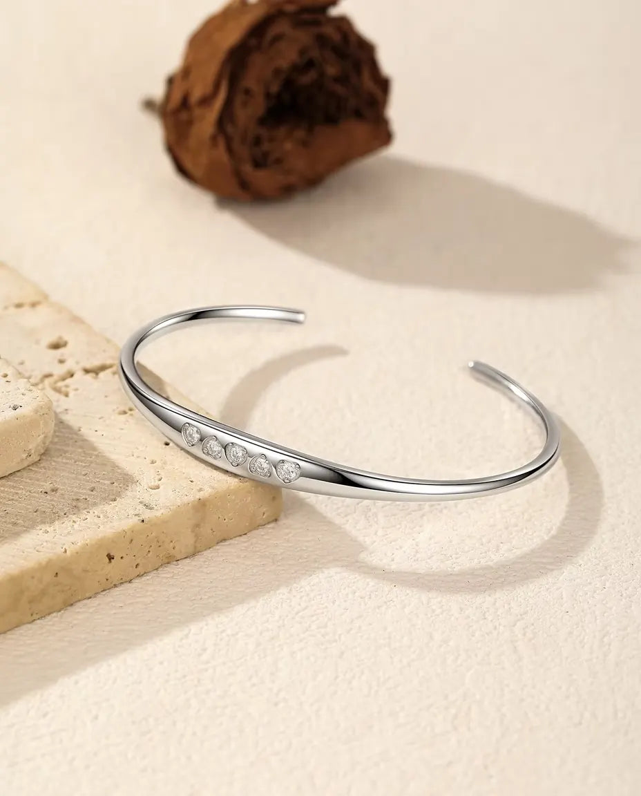 Öppet Moissanite Armband i 925 Sterlingsilver - draperat över en travertinplatta