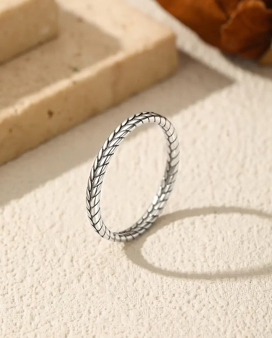 Ring med Veteaxmönster i 925 Sterlingsilver - stående på en ljus strukturerad yta