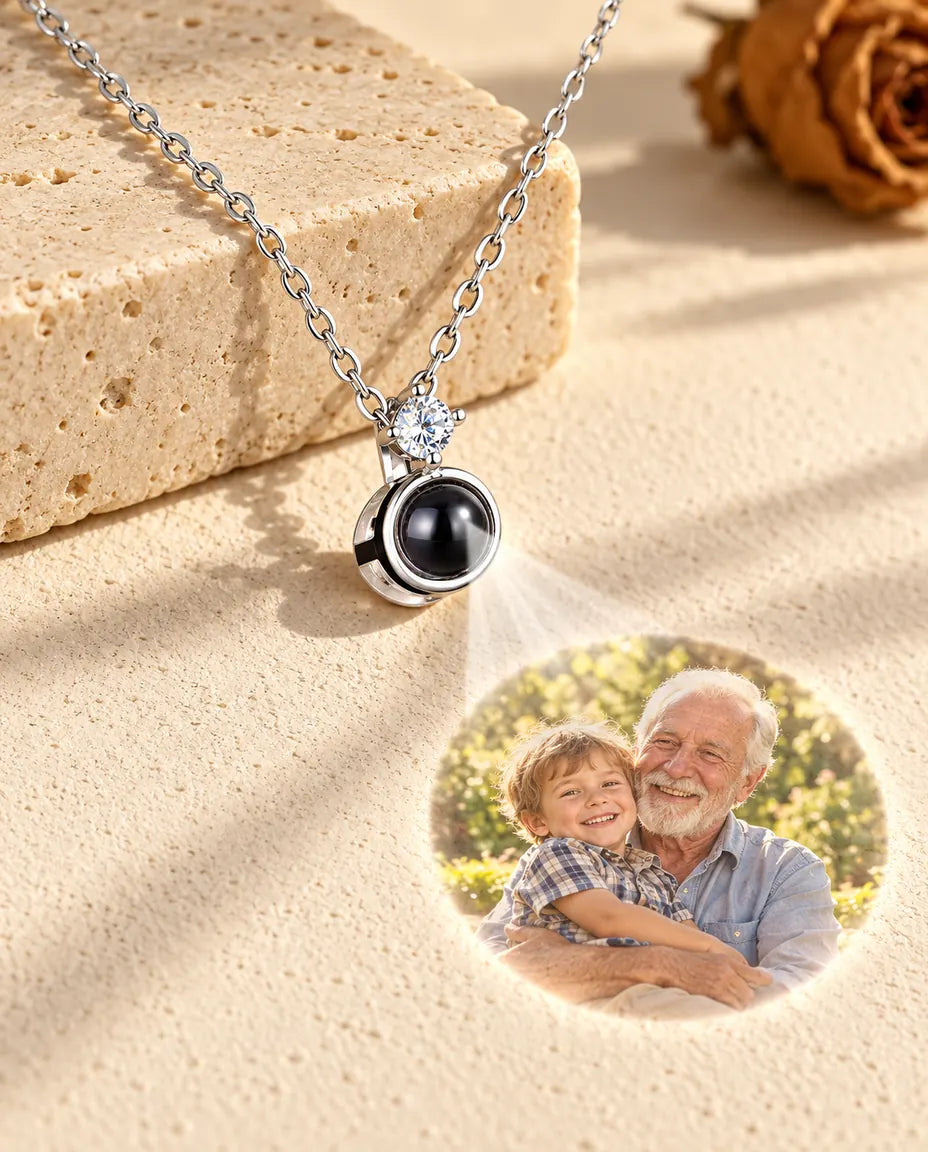 Silverfärgat solitärhalsband projicerar en bild på en äldre man och hans barnbarn mot gips