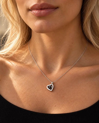 Kvinna i svart stickad topp bär det lilla dubbelhjärtat i sterlingsilver med bild inuti