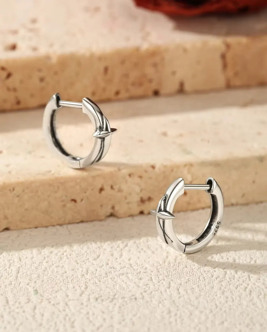 Små Creoler med Fyruddig Stjärna i 925 Sterlingsilver - paret på trappsteg av travertin