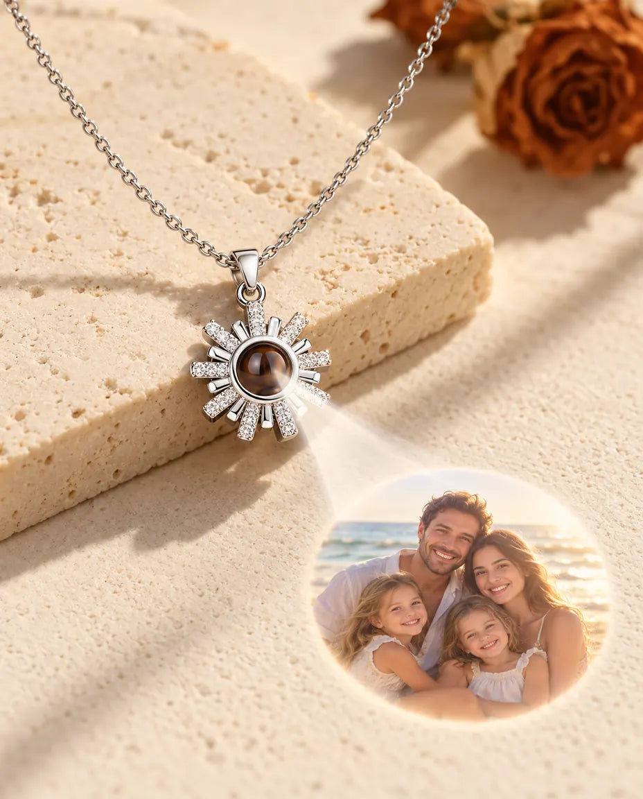 Silverfärgat solhalsband projicerar en bild på en familj på stranden mot krämvit gips