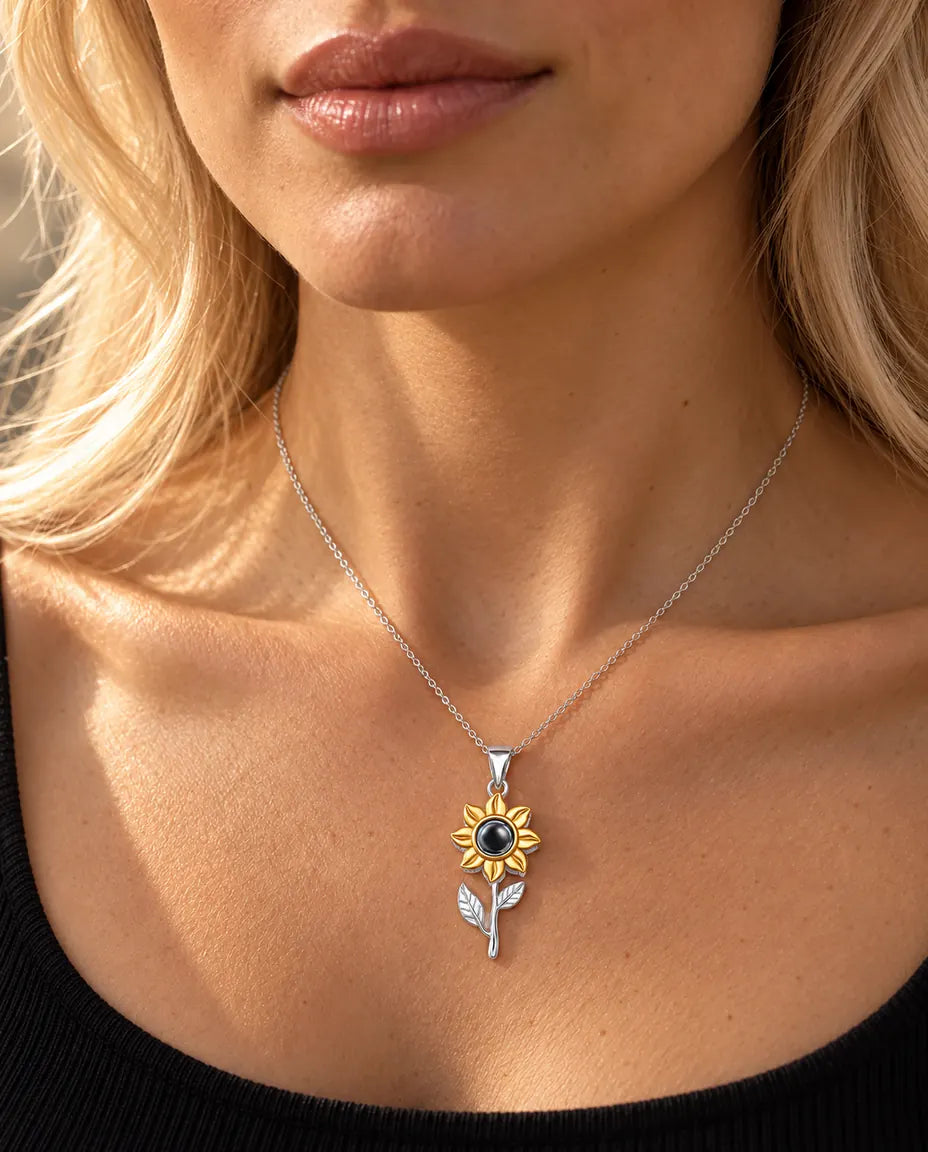 Kvinna i svart topp bär halsbandet med solros på stjälk i 925 sterlingsilver
