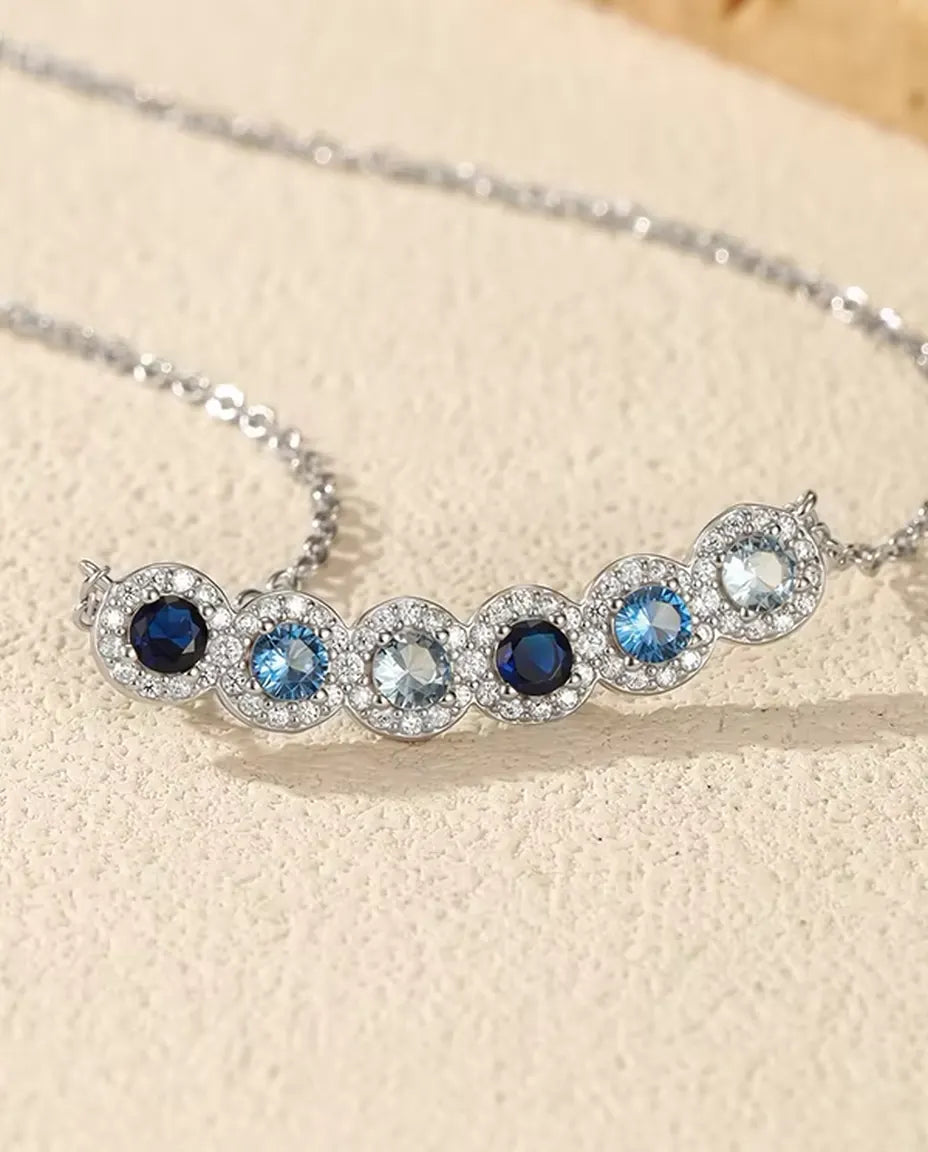 Stavhalsband Blå Toning - sex blå stenar med pavéhalo, böjd stav 34 mm, 925 sterling silver, 40+5 cm