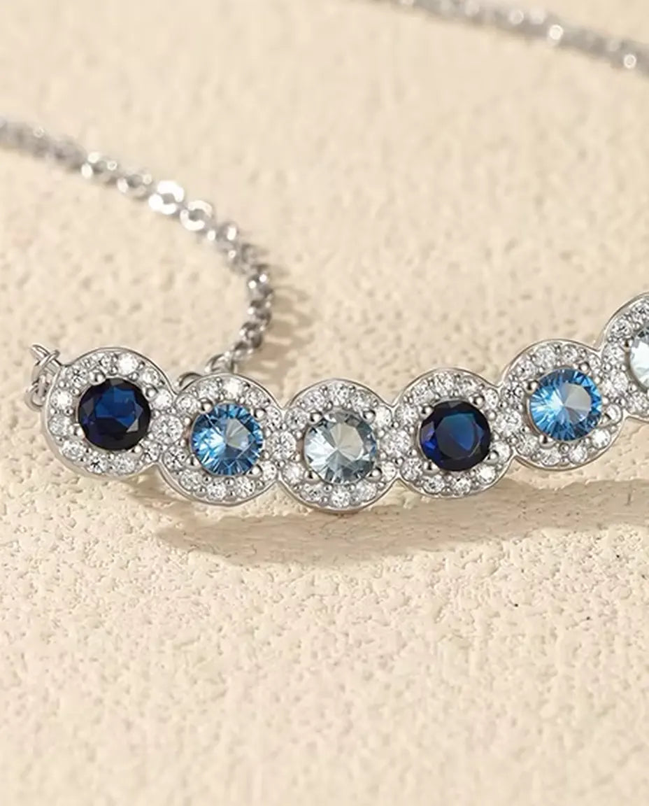 Stavhalsband Blå Toning - sex blå stenar med pavéhalo, böjd stav 34 mm, 925 sterling silver, 40+5 cm