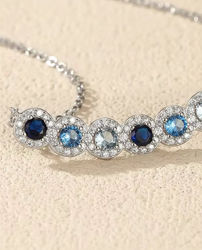 Stavhalsband Blå Toning - sex blå stenar med pavéhalo, böjd stav 34 mm, 925 sterling silver, 40+5 cm