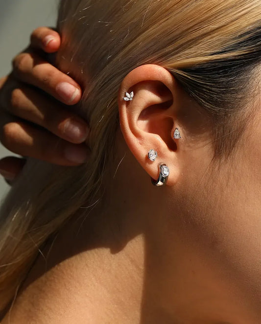 Stiftörhängen med Oval Moissanite i Sidofattning i 925 Sterlingsilver - buret av en modell med handen bakom huvudet